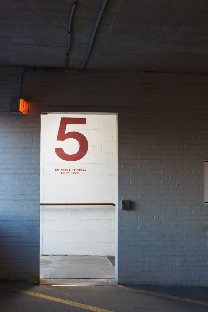 Entrance to a parking garage level with signage and door.